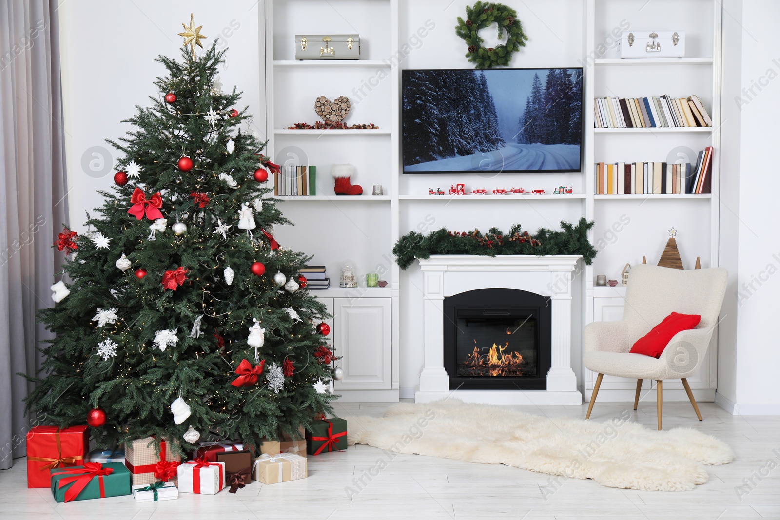 Photo of Beautifully decorated Christmas tree near fireplace in room. Festive interior design