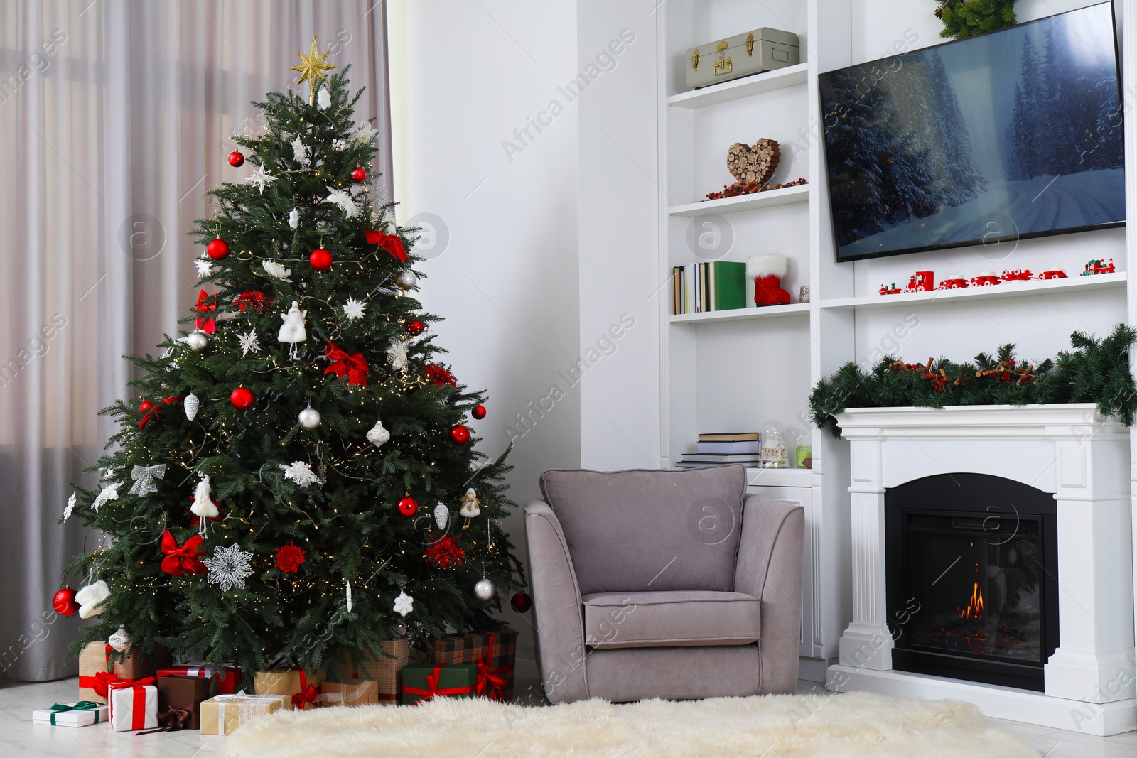 Photo of Beautifully decorated Christmas tree near fireplace in room. Festive interior design