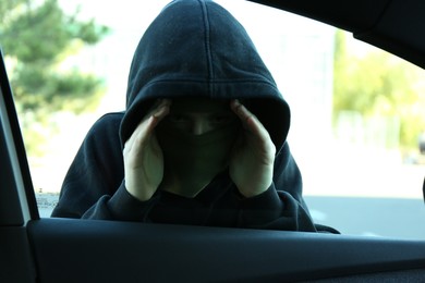 Photo of Thief looking into car through side window