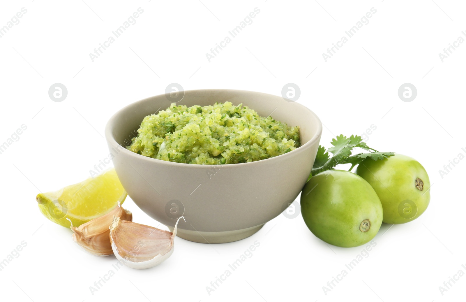 Photo of Delicious homemade green salsa and ingredients isolated on white