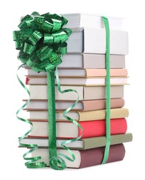 Photo of Stack of books with green bow as gift isolated on white