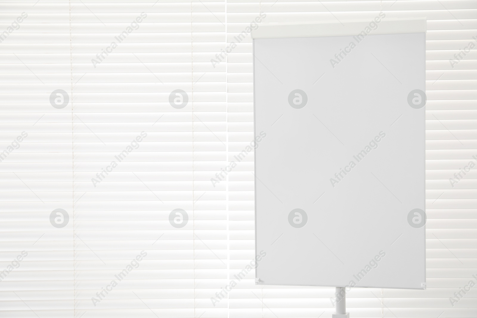 Photo of Flip chart near window in office. Mockup for design