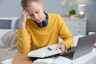 Photo of Student preparing for exam at table indoors