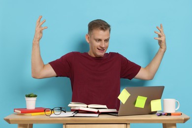 Photo of Student preparing for exam at table against light blue background