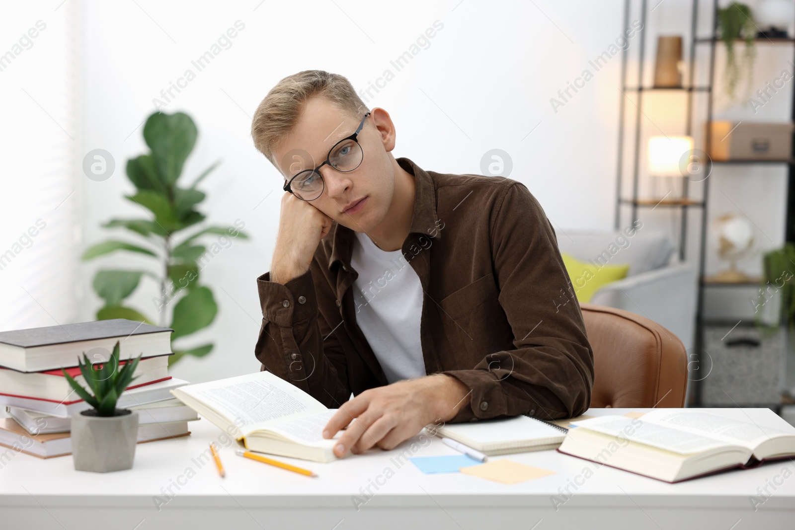 Photo of Preparing for exam. Student with books at table indoors