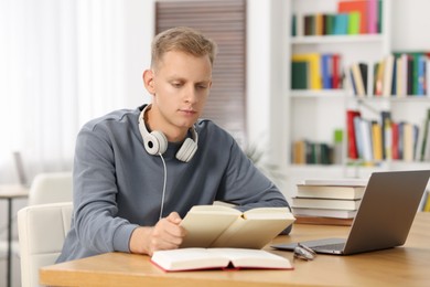 Photo of Student preparing for exam at table indoors