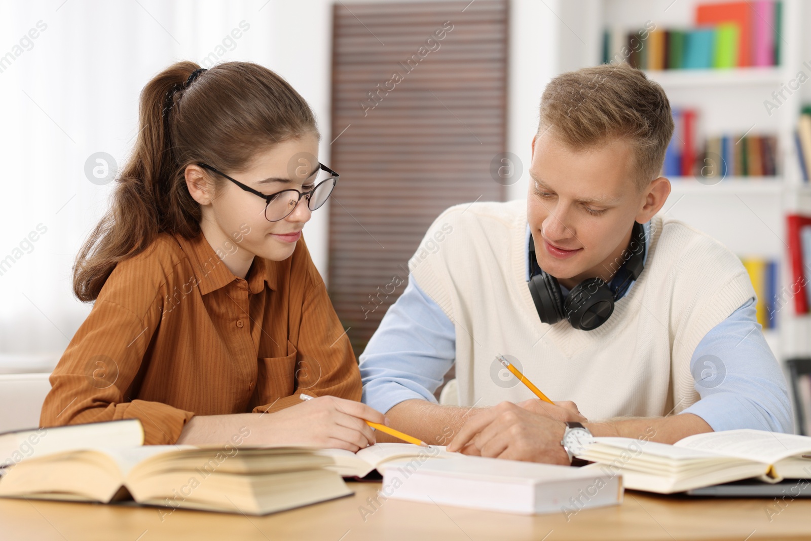 Photo of Students preparing for exam at table indoors