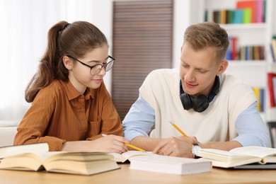 Photo of Students preparing for exam at table indoors