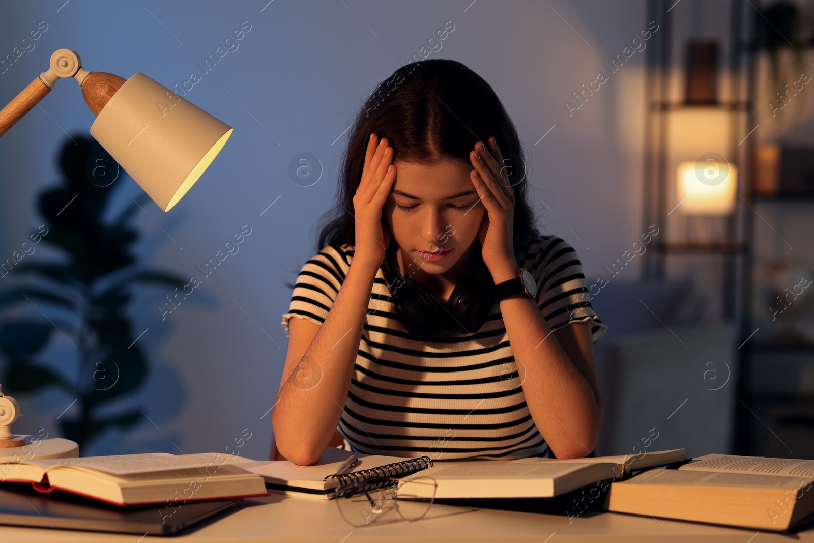 Photo of Preparing for exam. Tired student with books at table indoors