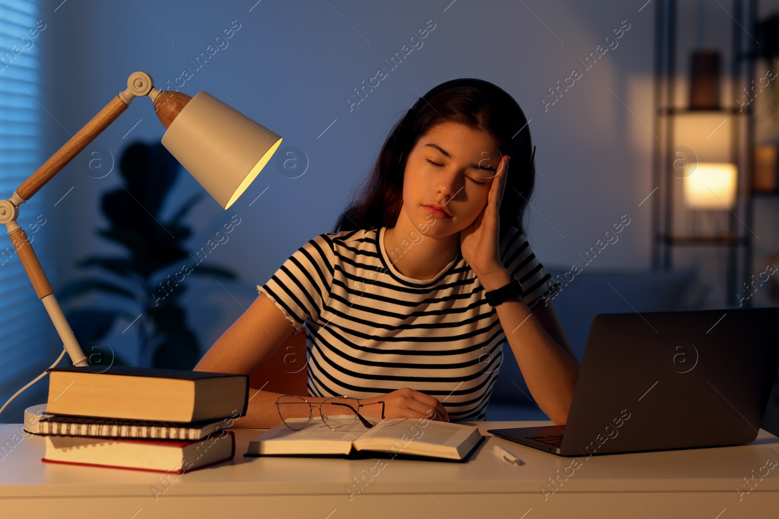 Photo of Preparing for exam. Tired student sleeping at table indoors