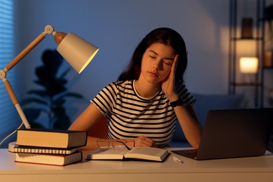 Photo of Preparing for exam. Tired student sleeping at table indoors