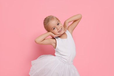 Photo of Little girl pretending to be ballerina on pink background. Dreaming of future profession