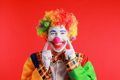 Photo of Portrait of happy clown on red background