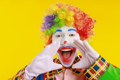 Photo of Portrait of clown screaming on yellow background