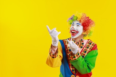 Photo of Portrait of happy clown on yellow background, space for text