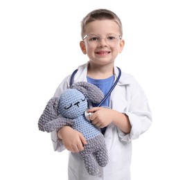 Photo of Little boy with stethoscope and toy pretending to be doctor on white background. Dreaming of future profession