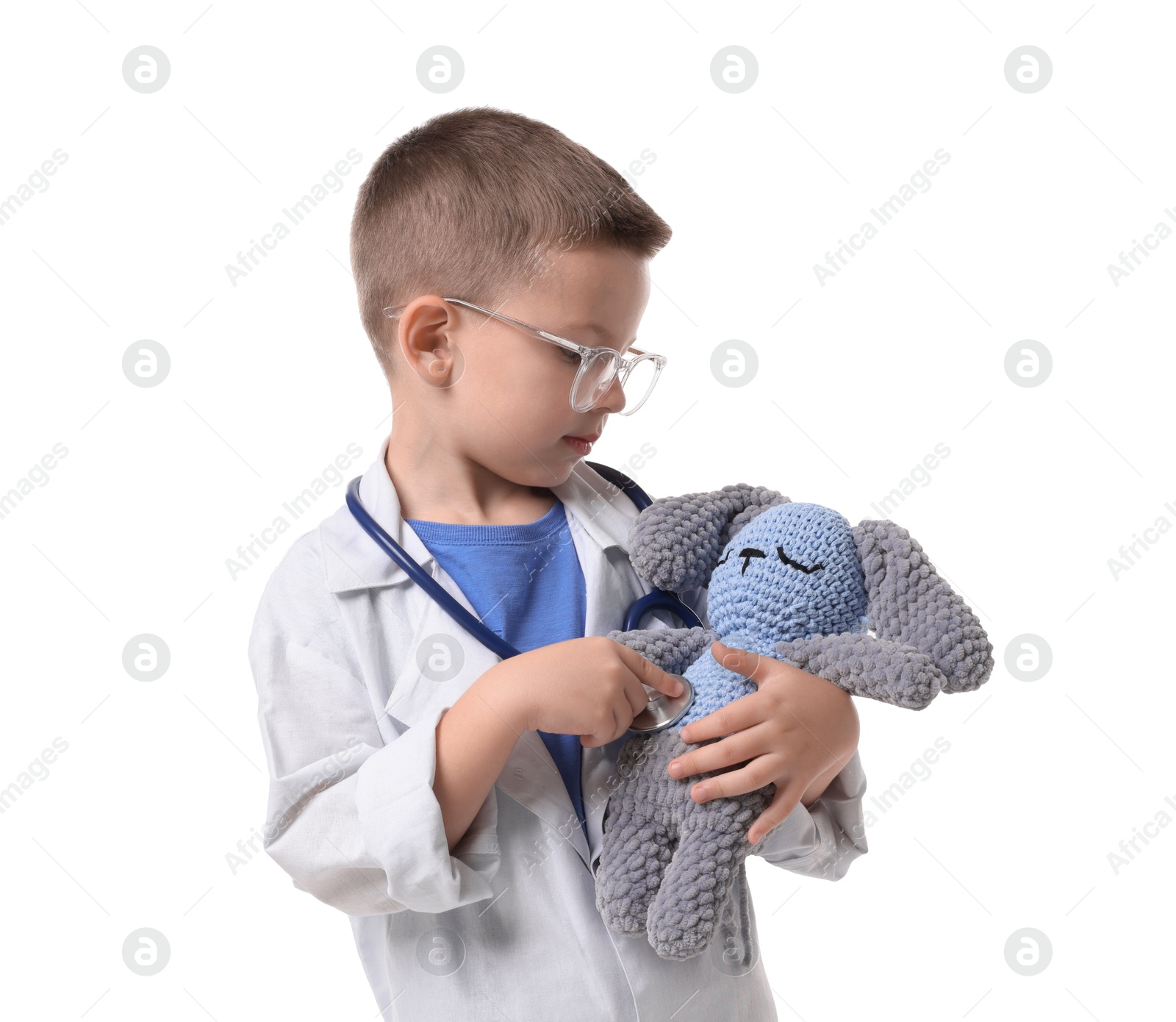 Photo of Little boy with stethoscope and toy pretending to be doctor on white background. Dreaming of future profession