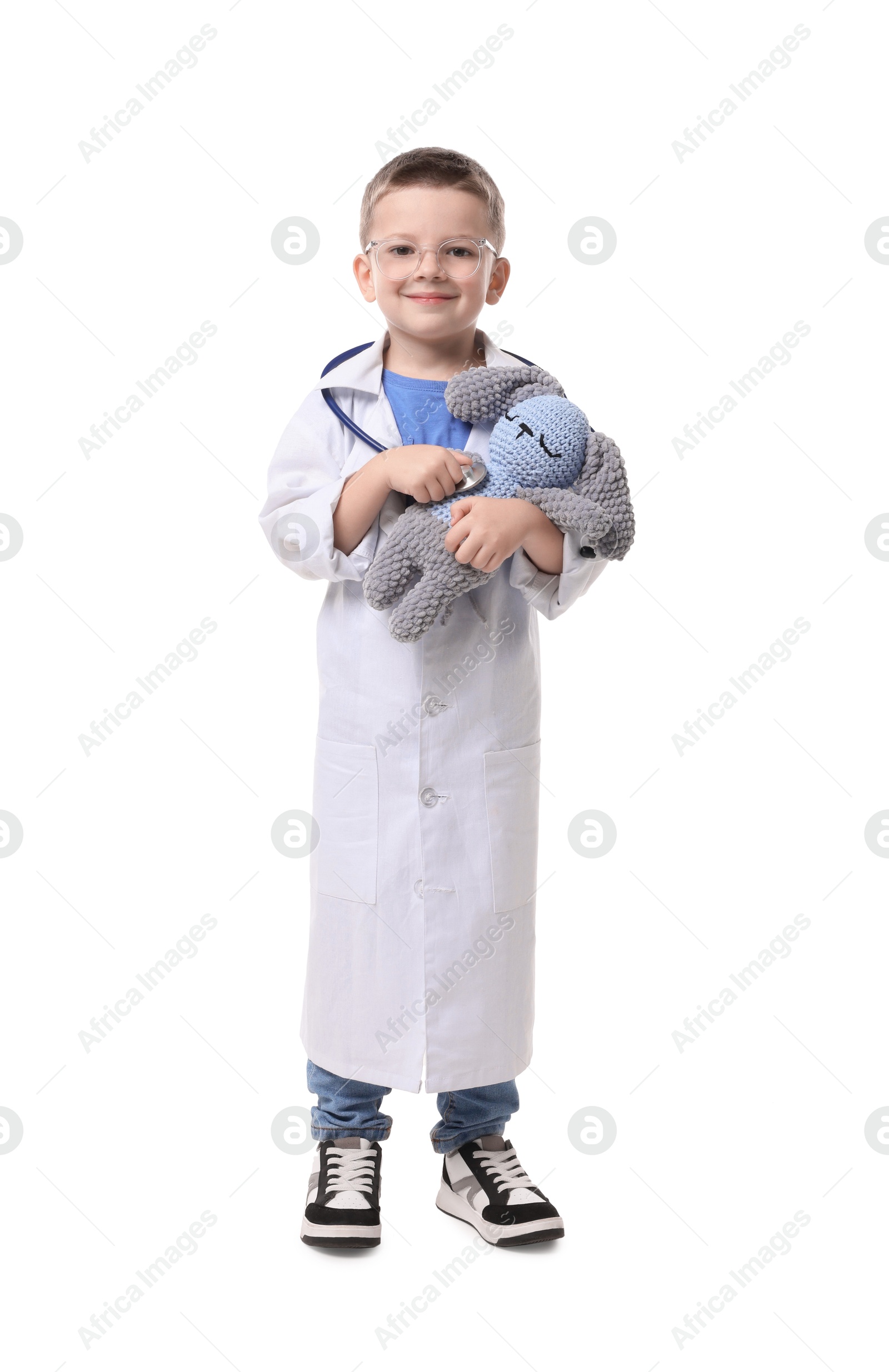 Photo of Little boy with stethoscope and toy pretending to be doctor on white background. Dreaming of future profession