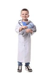 Photo of Little boy with stethoscope and toy pretending to be doctor on white background. Dreaming of future profession