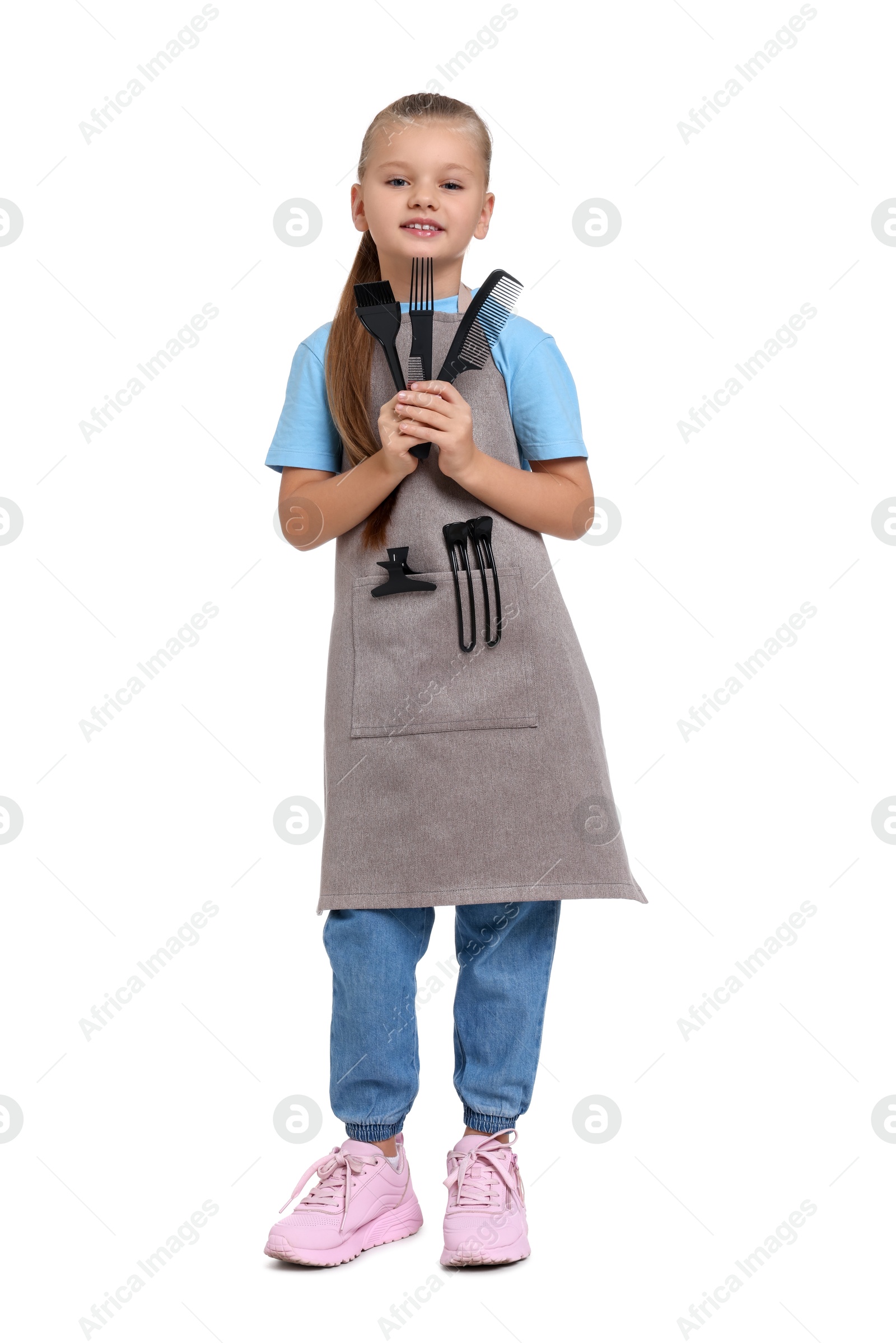 Photo of Little girl with brush and combs pretending to be hairdresser on white background. Dreaming of future profession