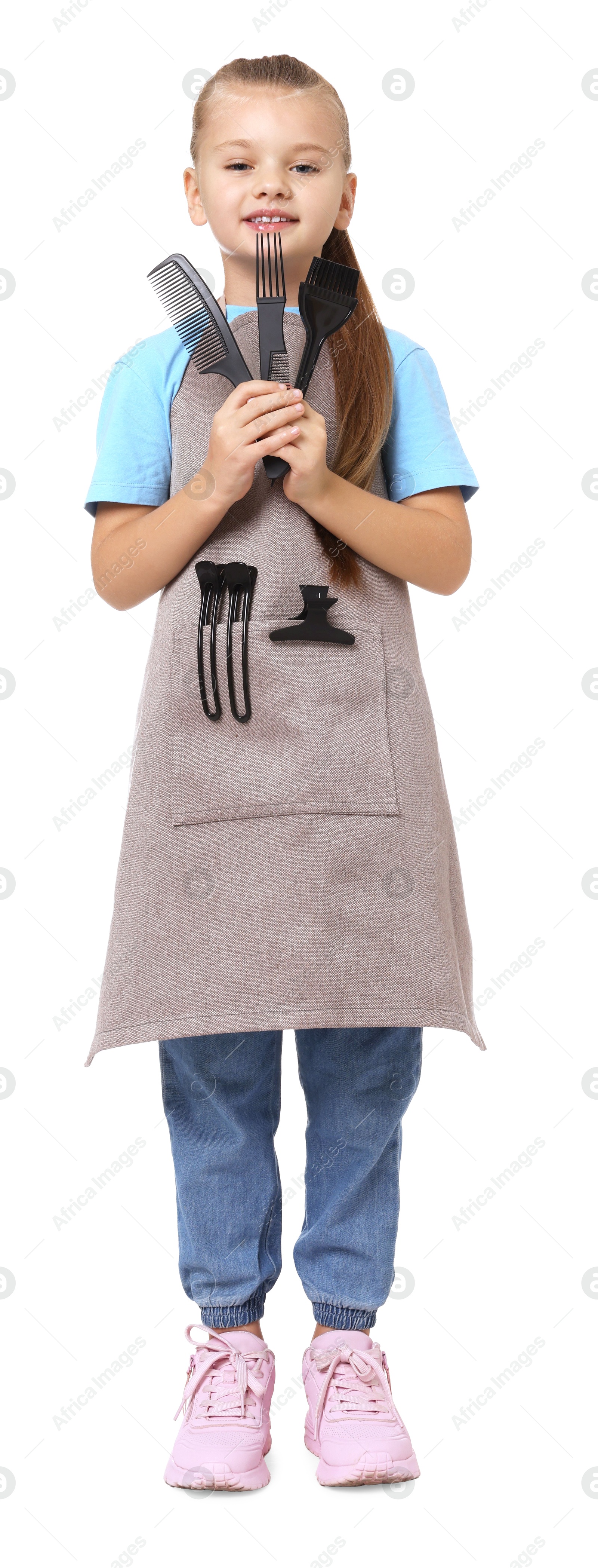 Photo of Little girl with brush and combs pretending to be hairdresser on white background. Dreaming of future profession