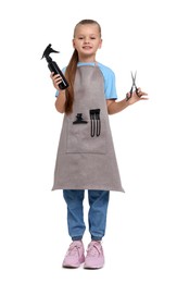 Photo of Little girl with scissors and sprayer pretending to be hairdresser on white background. Dreaming of future profession