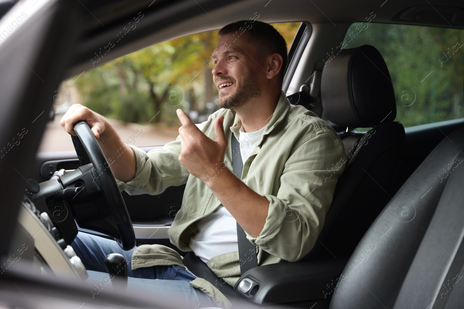 Photo of Man driving modern car, view through window