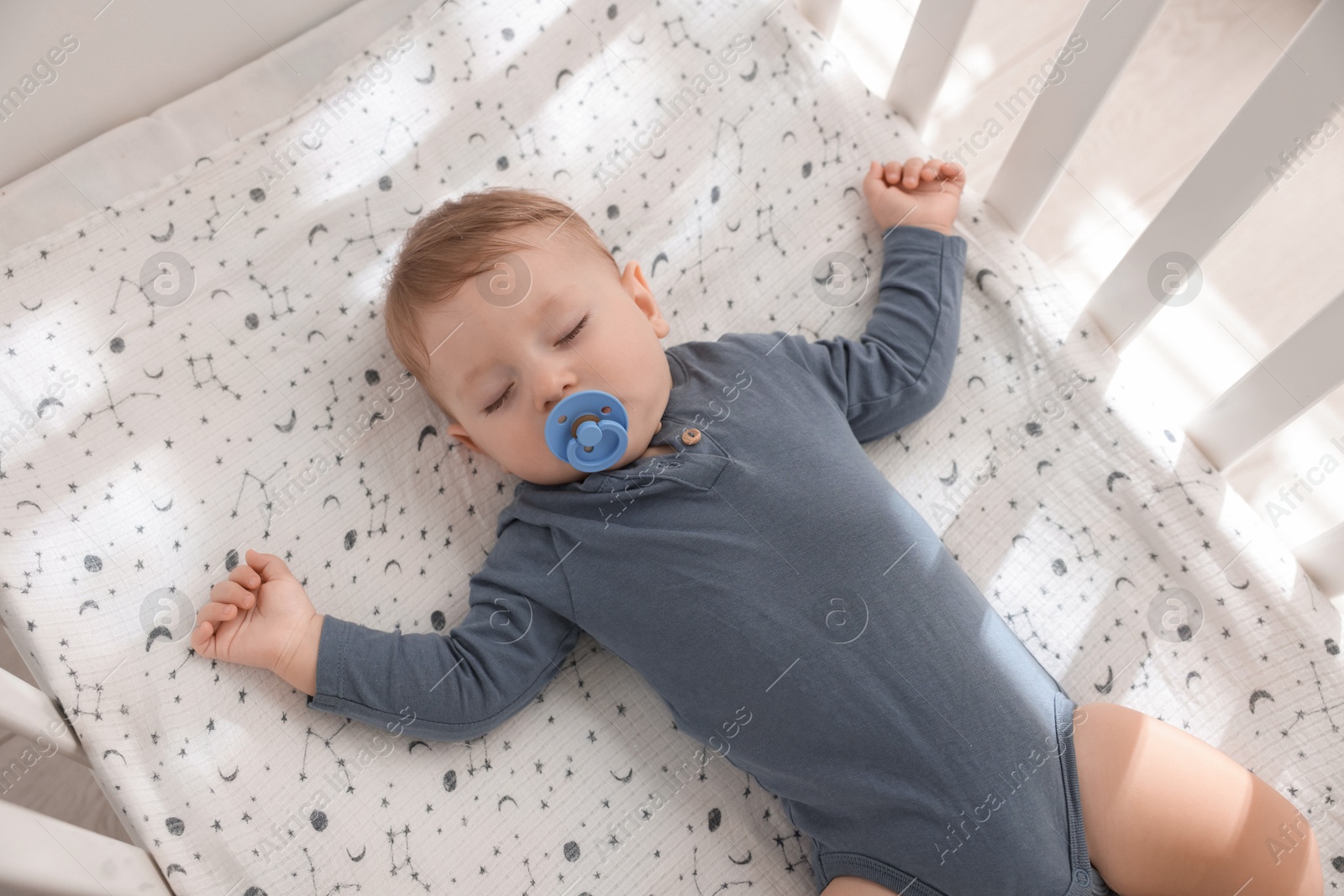 Photo of Cute baby sleeping in crib at home, top view