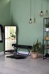 Photo of Stylish hallway interior with mirror and shelving unit