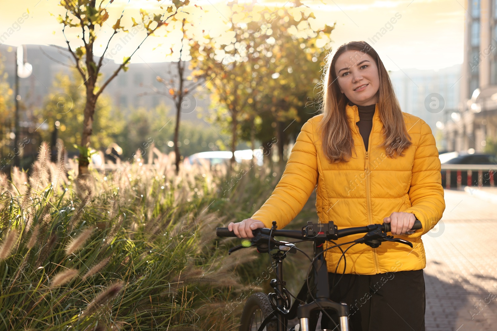 Photo of Woman with bicycle outdoors on sunny day