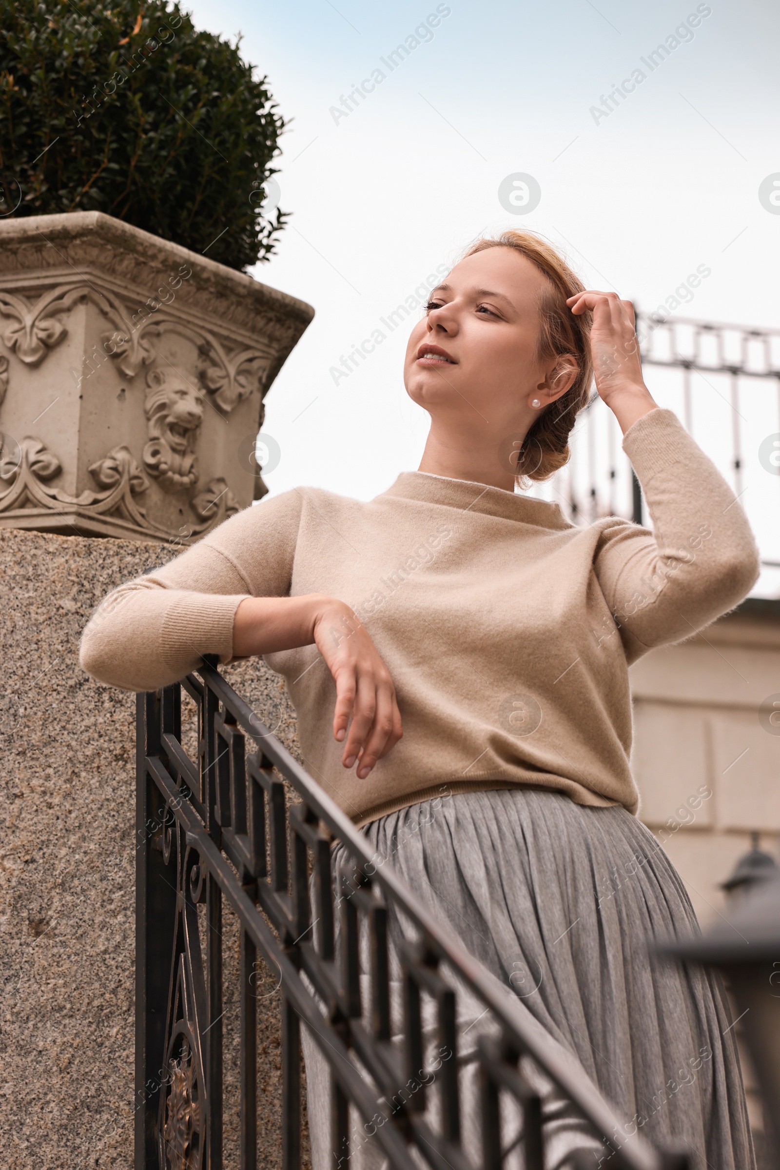 Photo of Beautiful young woman posing outdoors, low angle view