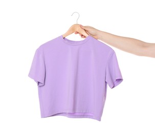 Photo of Woman holding hanger with violet t-shirt on white background, closeup