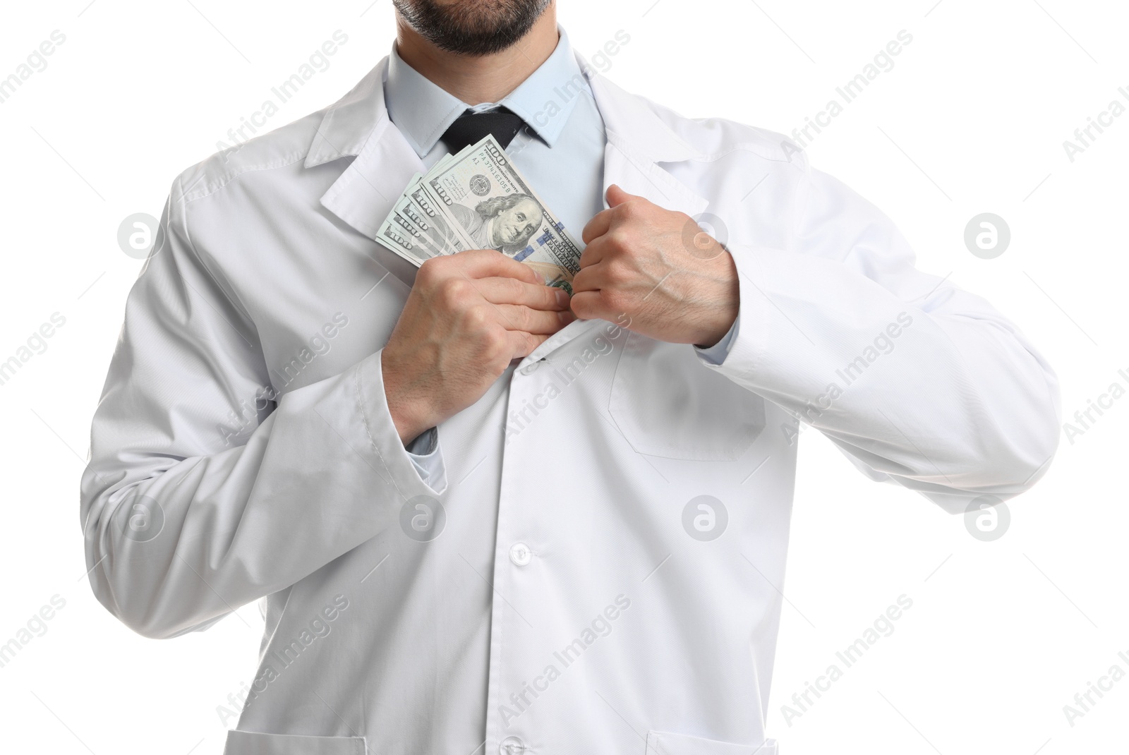 Photo of Corruption concept. Doctor putting dollar banknotes into his coat on white background, closeup