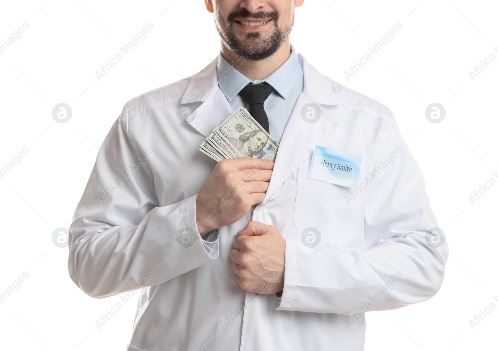 Photo of Corruption concept. Doctor putting dollar banknotes into his coat on white background, closeup