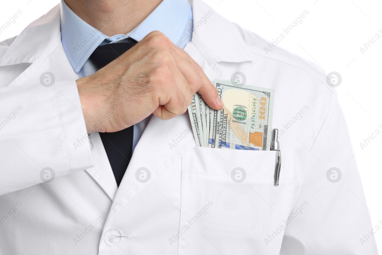 Photo of Corruption concept. Doctor putting dollar banknotes into his pocket on white background, closeup