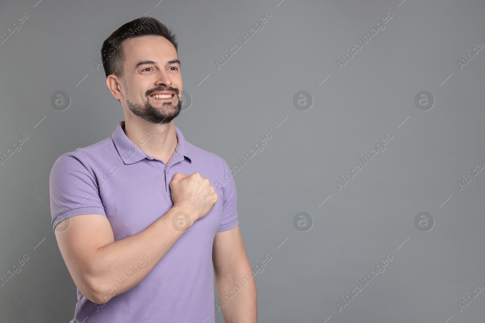 Photo of Man making promise on grey background, space for text. Oath gesture