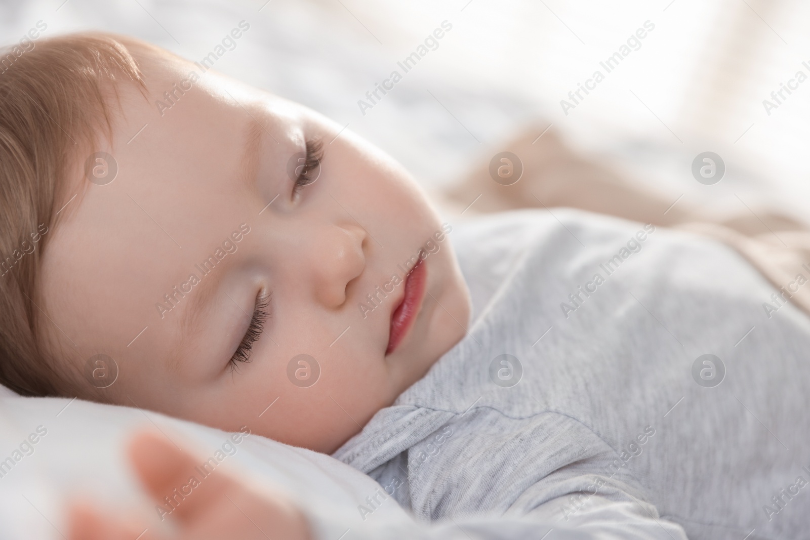 Photo of Cute little baby sleeping on bed at home, closeup