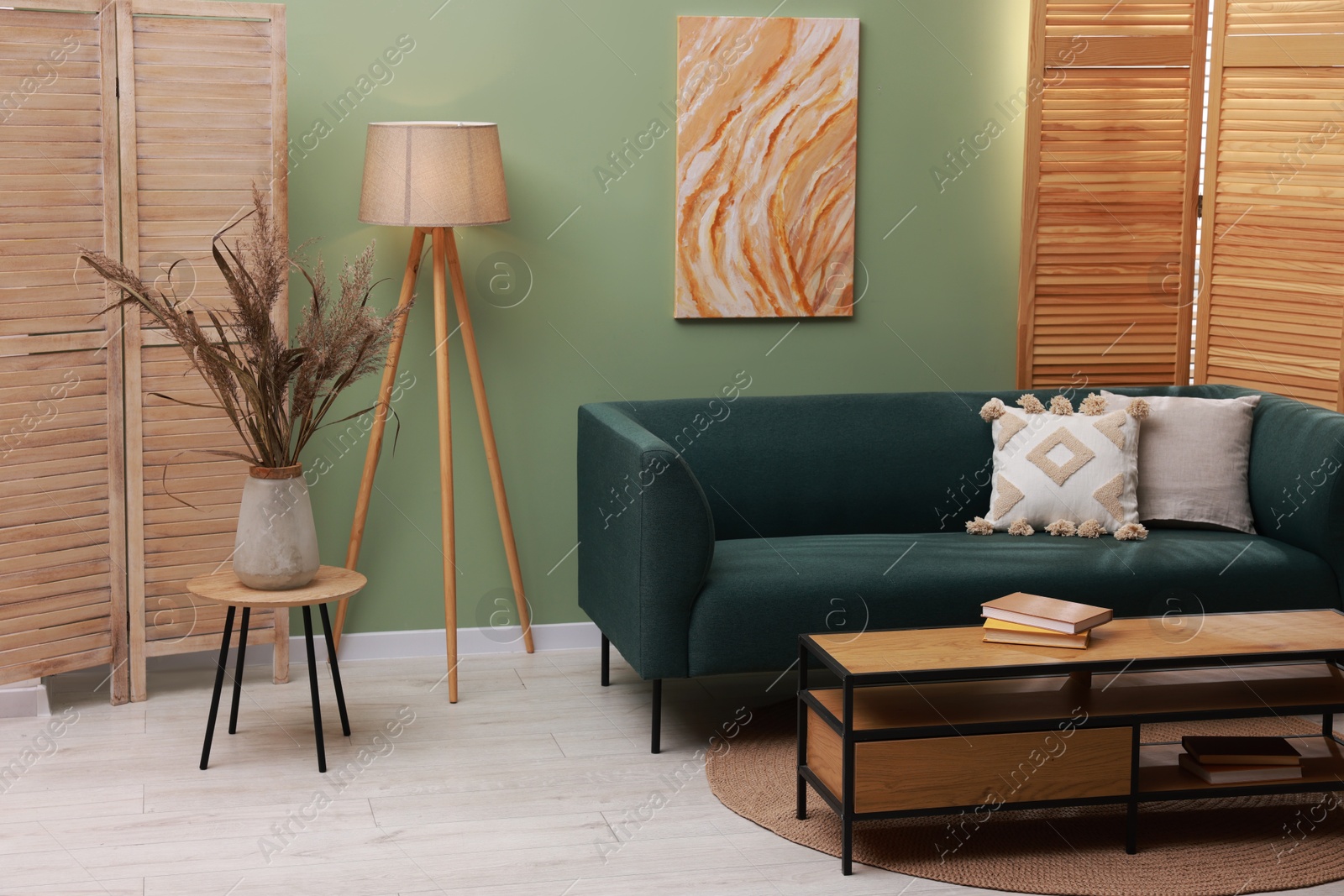 Photo of Soft sofa and other furniture near green wall in stylish living room