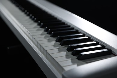 Photo of Synthesizer on black background, closeup. Electronic musical instrument