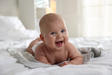 Photo of Cute little baby lying on bed indoors