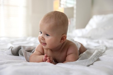 Photo of Cute little baby lying on bed indoors