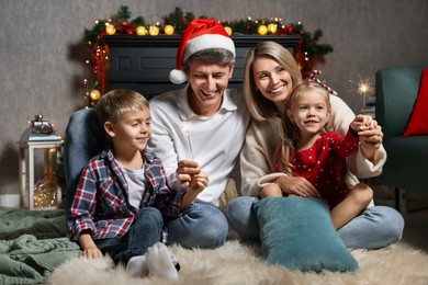 Photo of Lovely family with Christmas sparklers at home