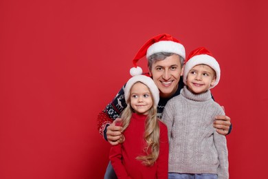 Photo of Father and his little children on red background, space for text. Christmas season