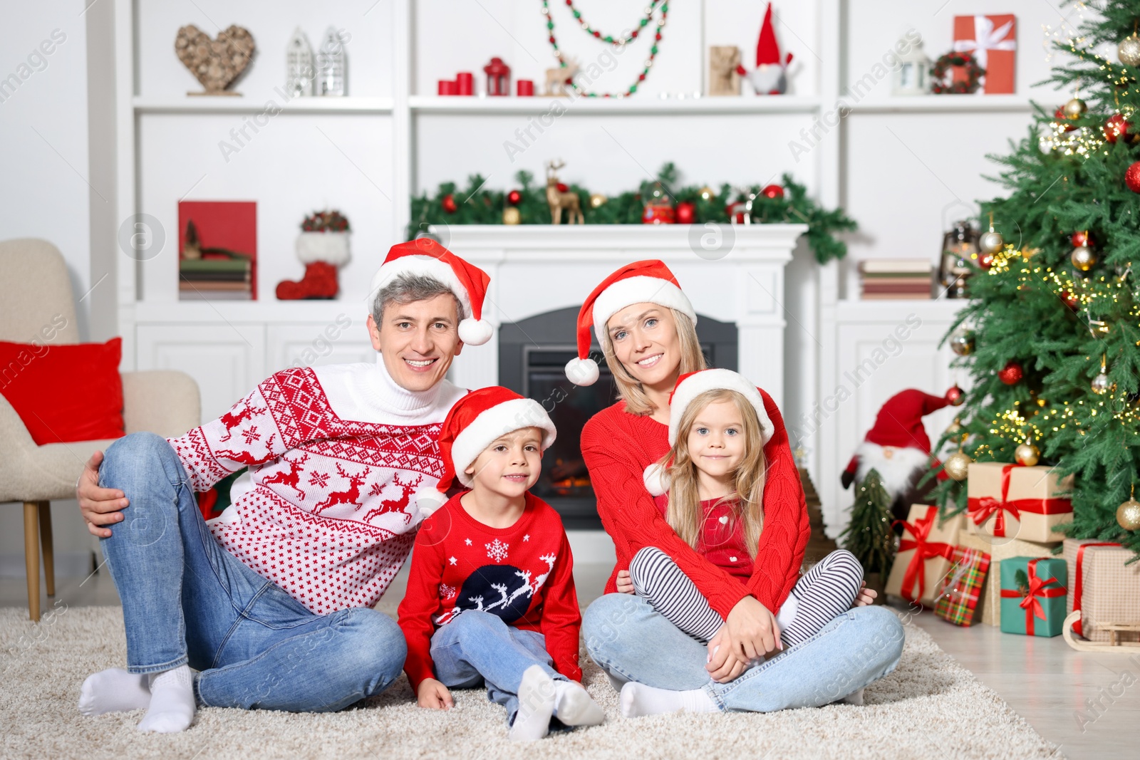 Photo of Lovely family in Christmas sweaters and Santa hats at home