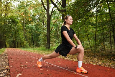 Photo of Young athletic woman stretching in park. Healthy lifestyle