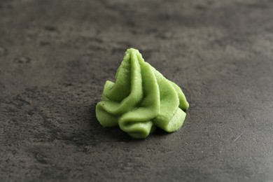 Photo of Hot wasabi paste on grey textured table, closeup