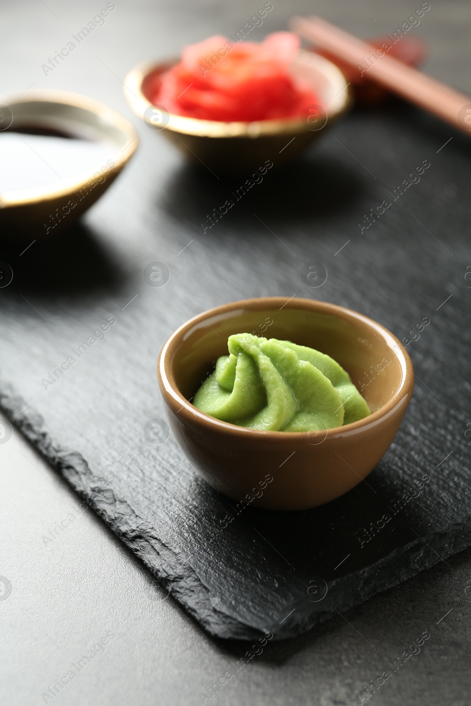 Photo of Hot wasabi paste on grey textured table, closeup