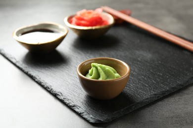 Photo of Hot wasabi paste on grey textured table, closeup