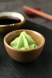 Photo of Hot wasabi paste and soy sauce on dark table, closeup