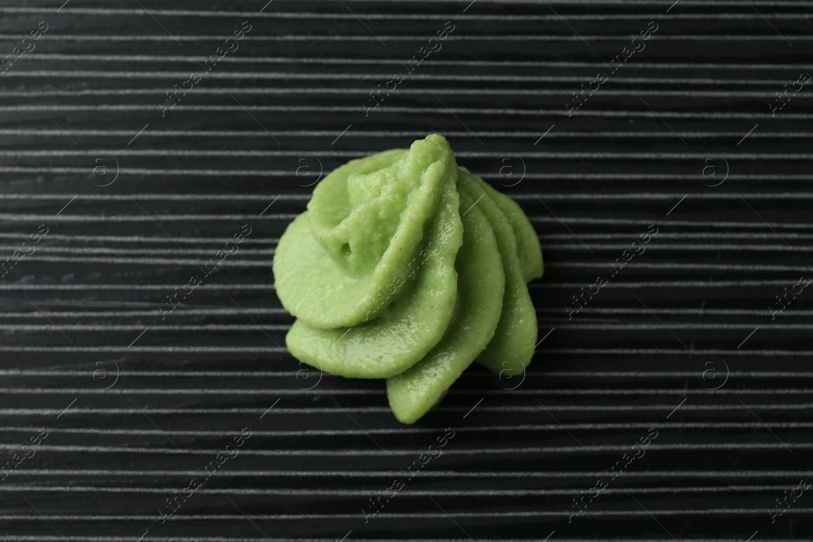 Photo of Hot wasabi paste on black textured table, top view